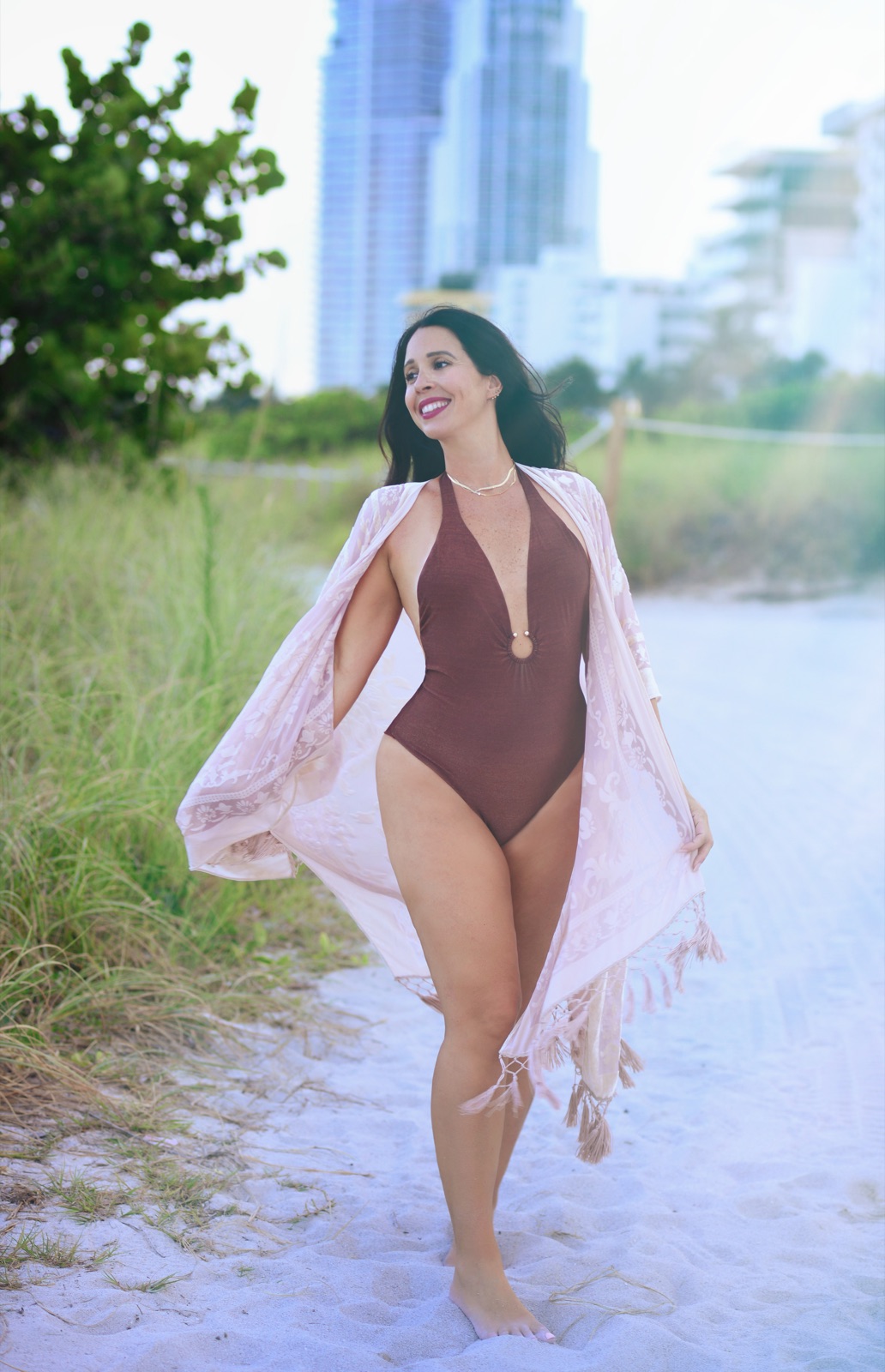 Jennifer Nicole walking the beach in a flowing cover-up